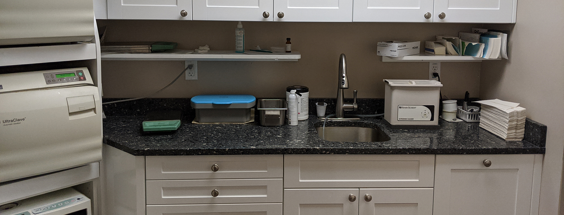 An organized office space with a countertop, storage cabinets, and various office supplies.