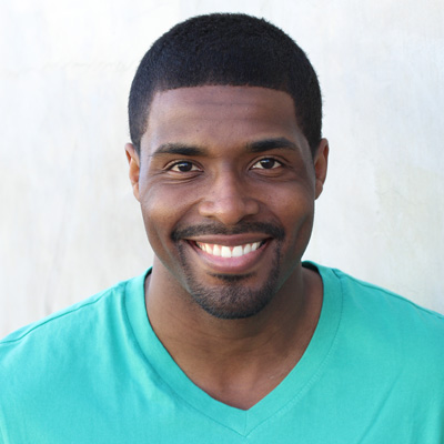 An elderly couple posing for a photo, with the man on the left and the woman on the right, both smiling at the camera.