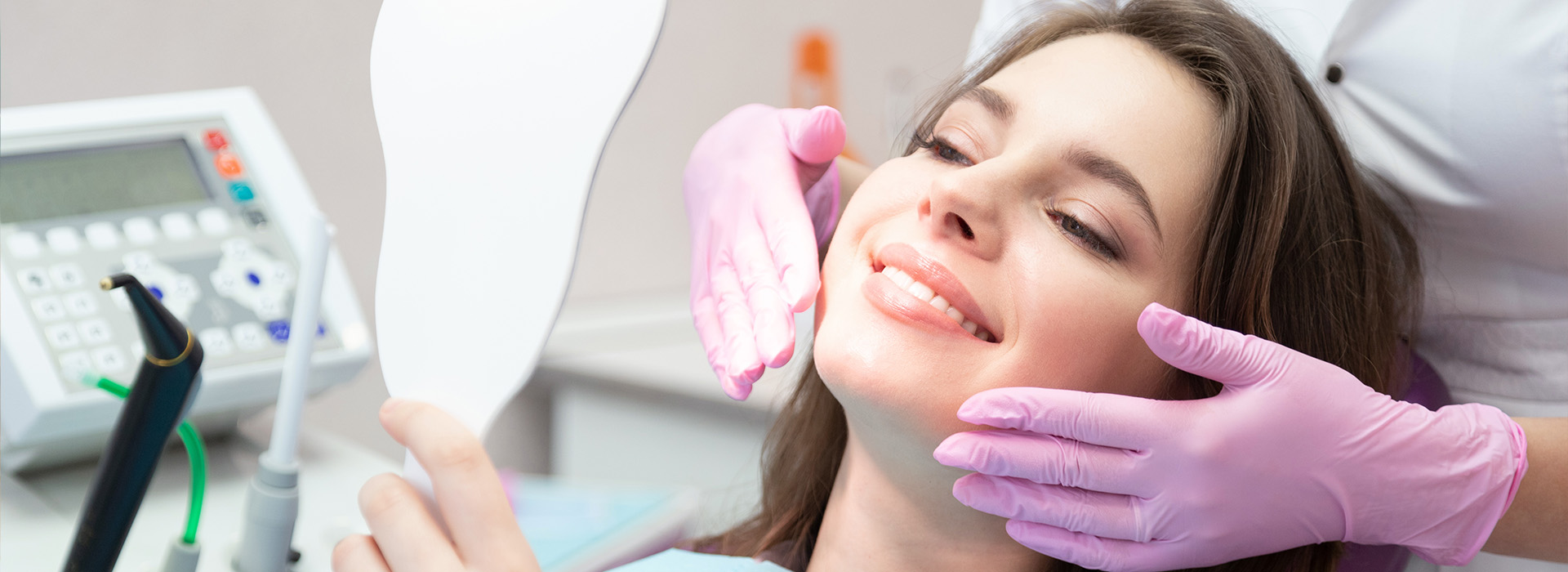 A woman receiving dental care with a dental hygienist performing a cleaning procedure.