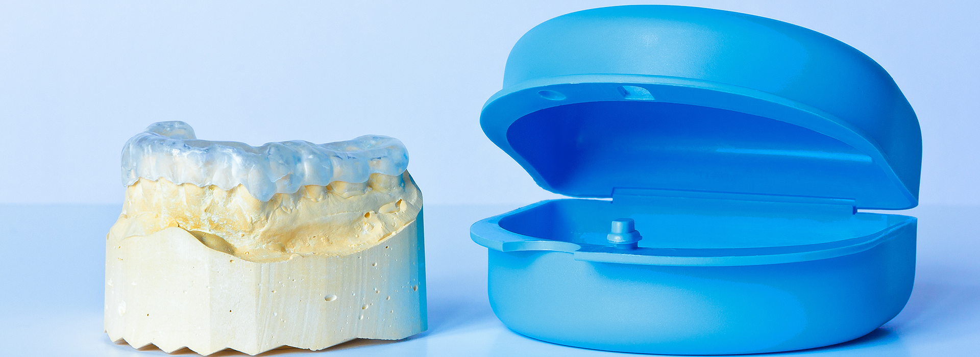 The image shows a close-up of a dental implant and an abutment, displayed against a blue background.