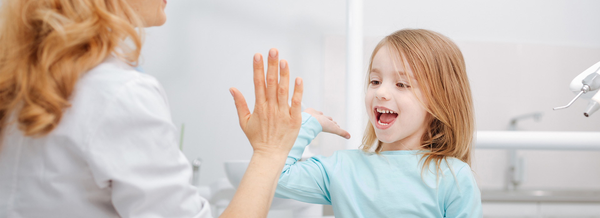 The image shows a woman and a young girl in a bathroom, with the woman s hand extended towards the child.