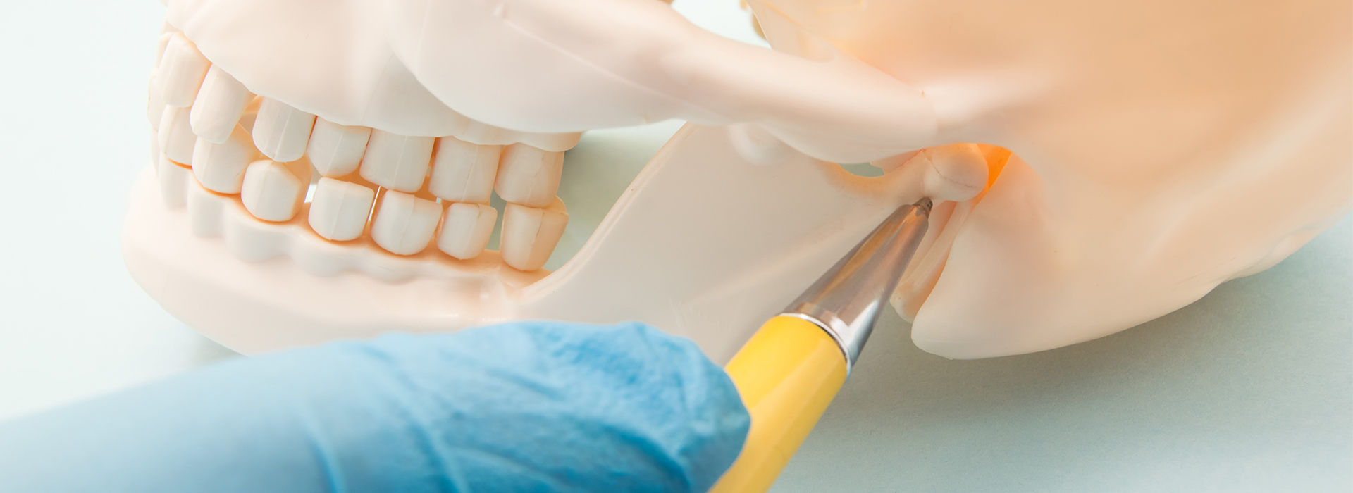 An image featuring a close-up of a dental implant procedure with a medical professional s hand holding a drill and a surgical instrument, set against a white background.